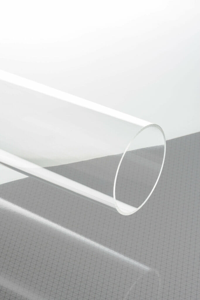 Klares Acrylrohr auf kariertem Hintergrund, ideal für vielseitige industrielle und dekorative Anwendungen.