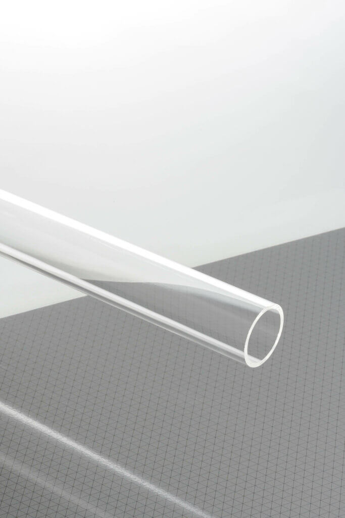 Klares Acrylrohr auf kariertem Tisch, ideal für DIY-Projekte und industrielle Anwendungen.