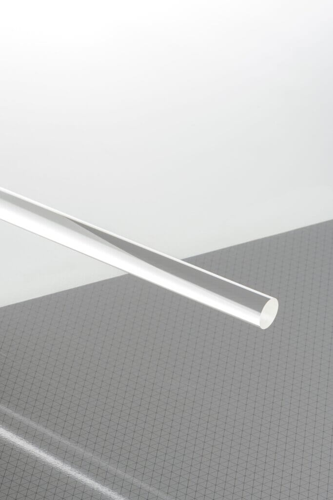 Transparente Acrylstange auf kariertem Hintergrund, ideale Wahl für DIY-Projekte, Modellausstellungen und Kunstinstallationen.