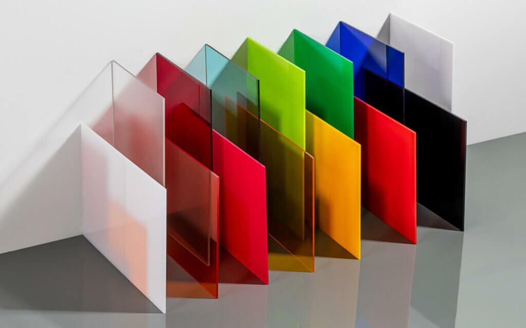 Bunte Acrylglasplatten in verschiedenen Farben und Transparenzen, nebeneinander aufgestellt für kreative Designideen.