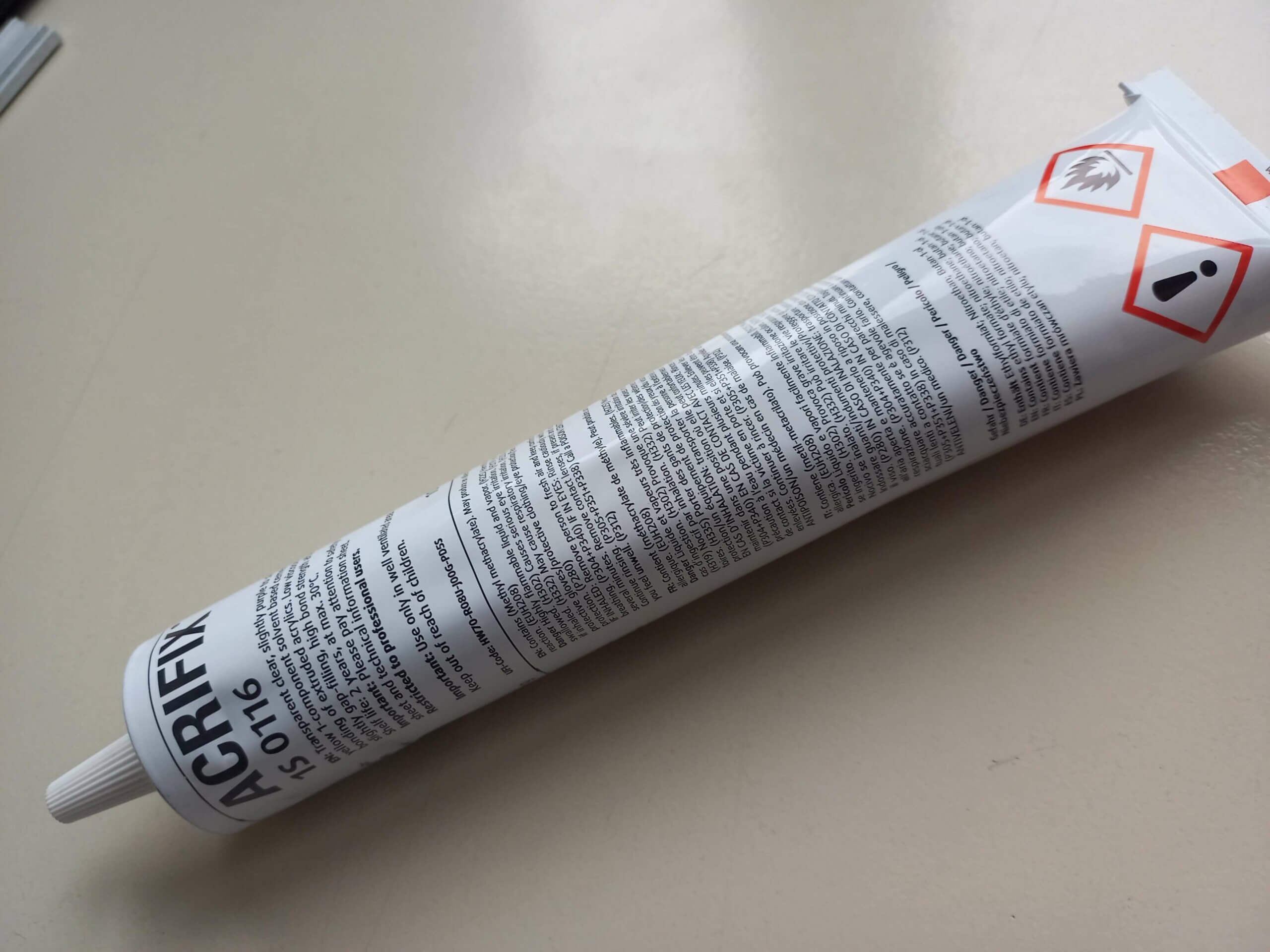 Acrifix Kleber in Tube auf Tisch für präzise Kunststoffverbindungen. Ideal für Heimwerkerprojekte und Reparaturen.